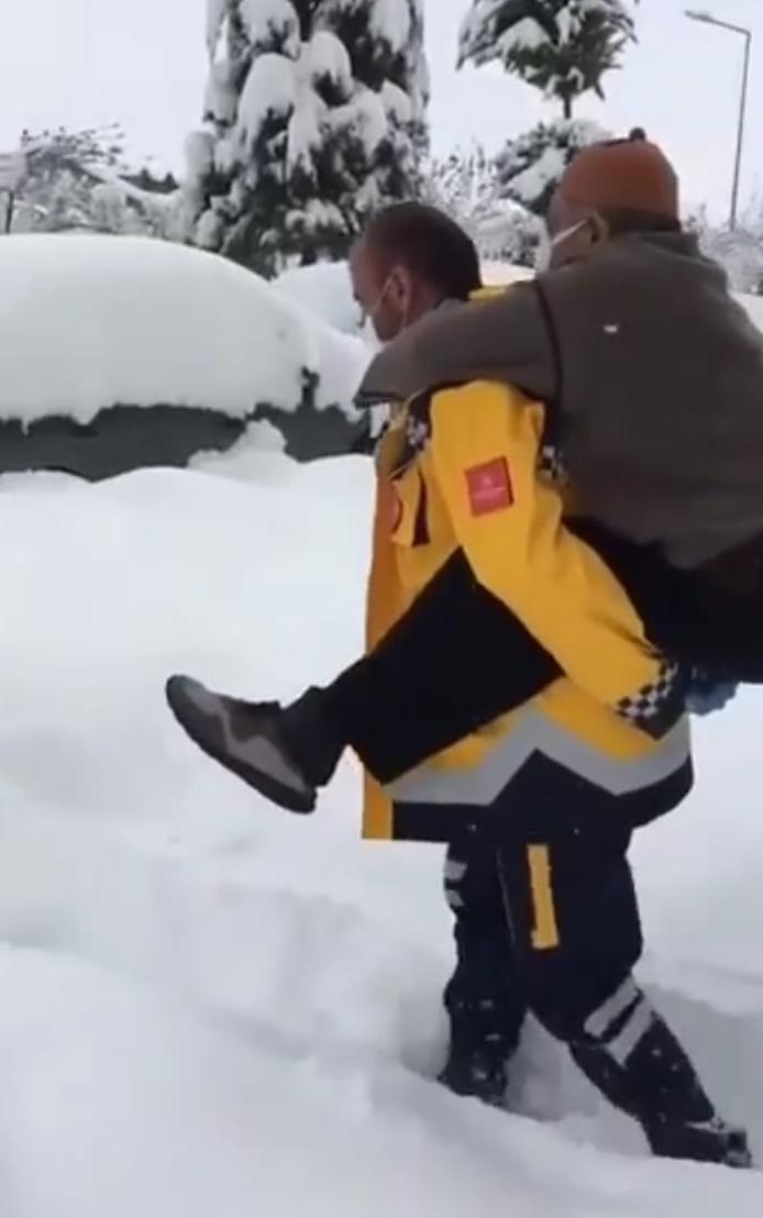 karda, kışta, ayazda vatandaşı sırtında taşıyan sağlık personelleri