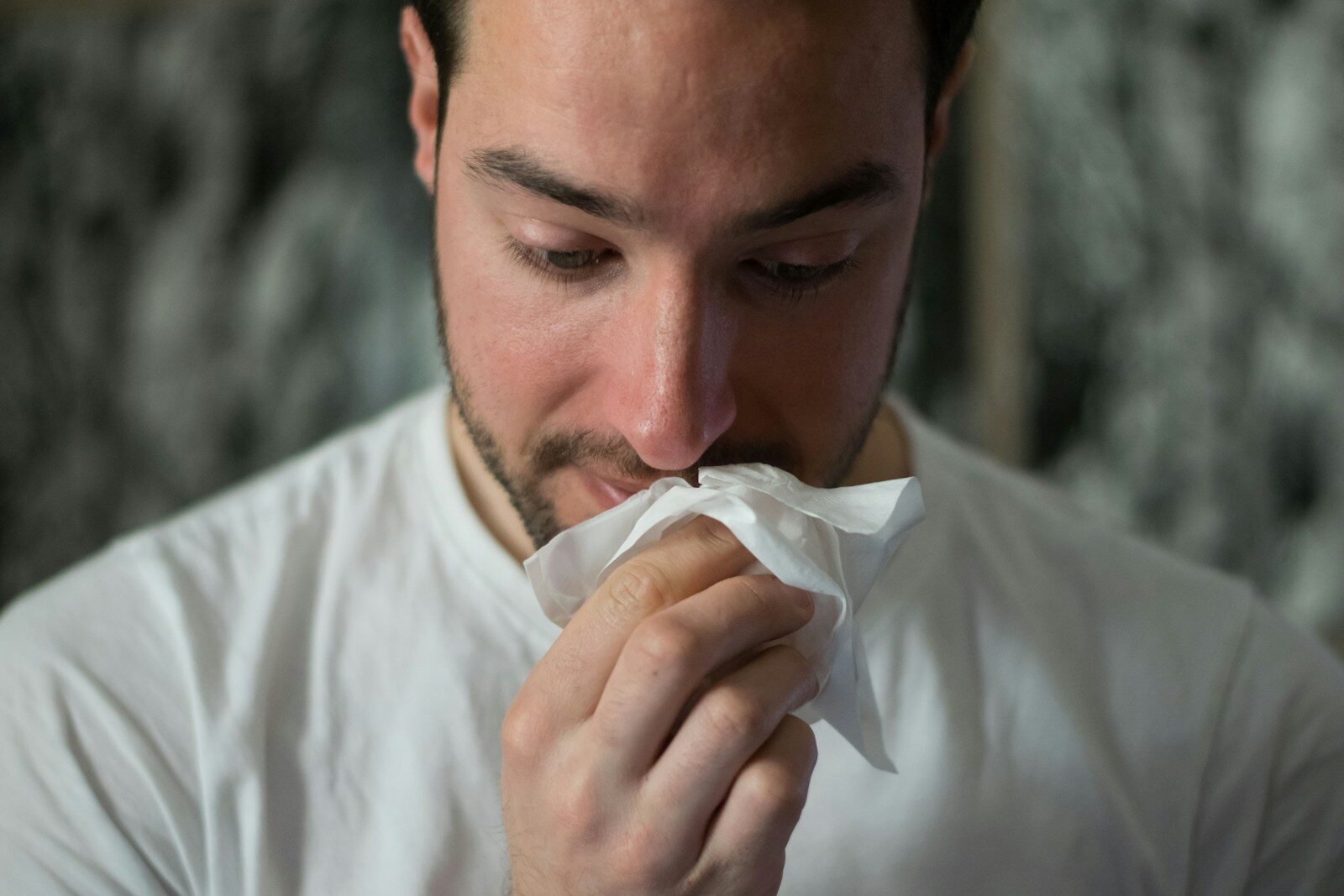 Burnumuz Neden Bir Tarafı Daha Fazla Tıkalı Hissediyor? sick man blowing nose into tissue